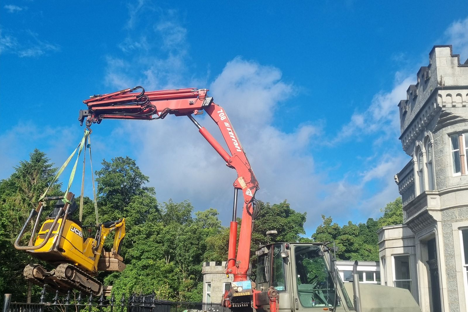 Lorry-mounted crane working beside a granite building