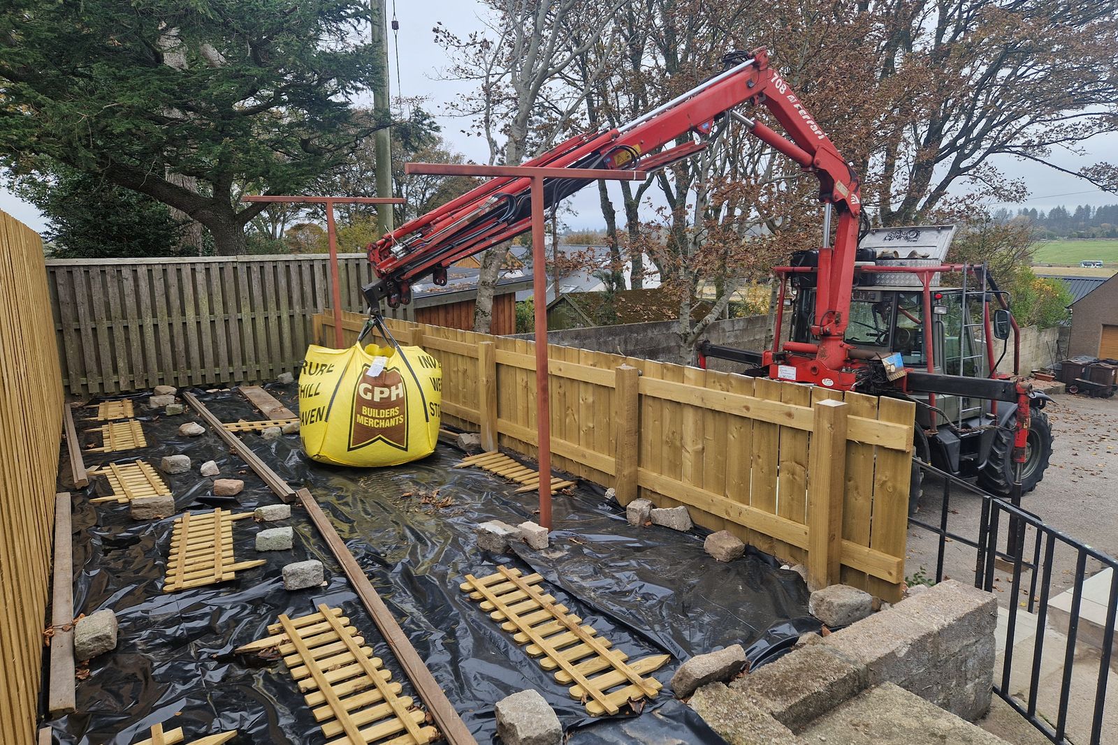 Crane lifting a bulk bag over a new fence line