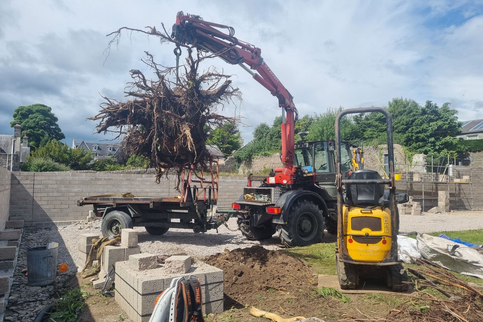 Crane lifting a large root mass clear of the garden