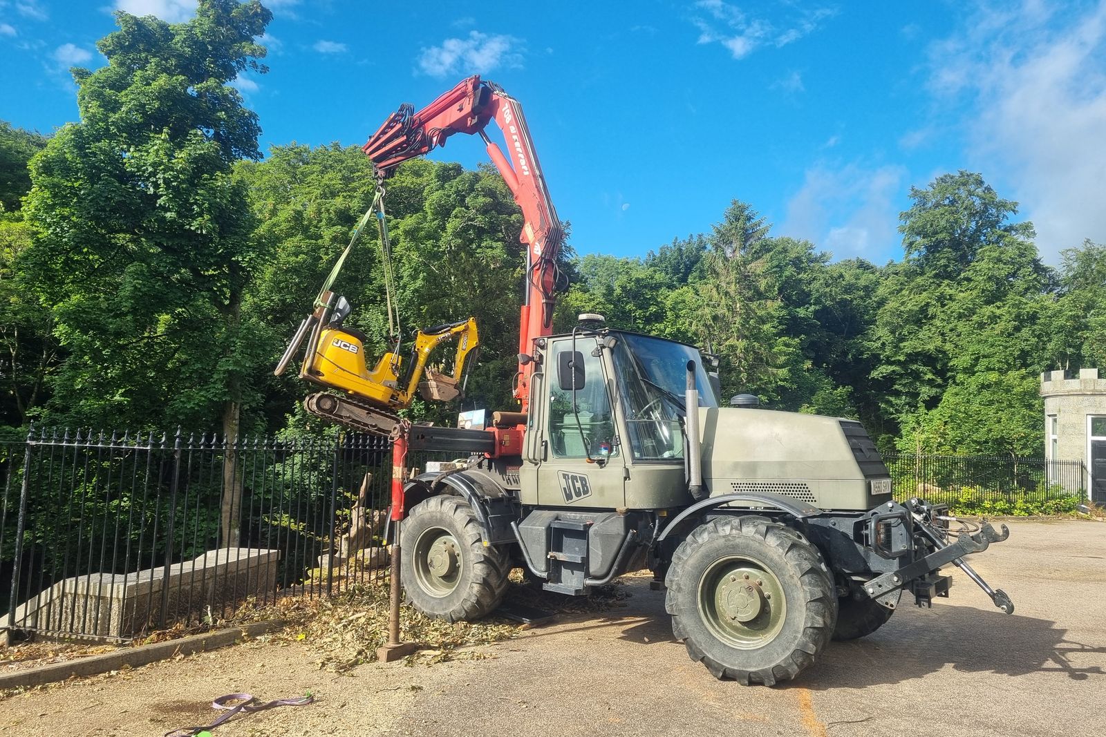 Crane-equipped Unimog set up at the gates of a granite house